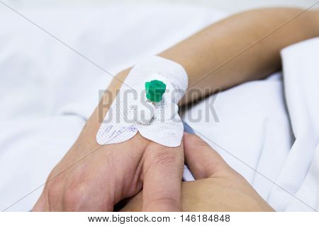 Injection cathetter in the hand of patient lying in the bed