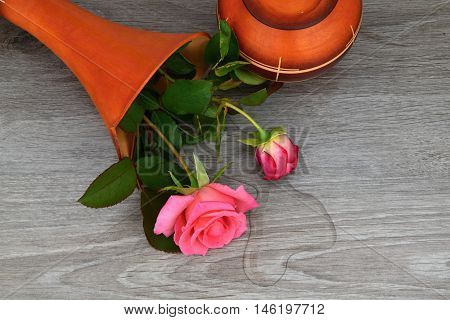 Capsize flower vase with roses. Water leaked out of a vase.