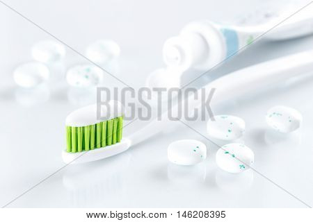 sqweezed green toothbrush on white background with bubble gums - concept for toothcare