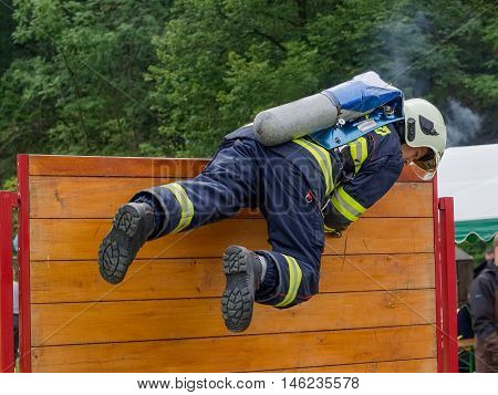 Firefighter overcomes wooden obstacle during the competition in fire sport.Contest TFA - Toughest Firefighter Alive