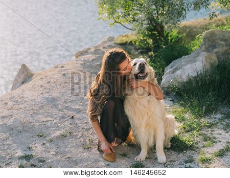 Beauty woman with her dog playing outdoors.