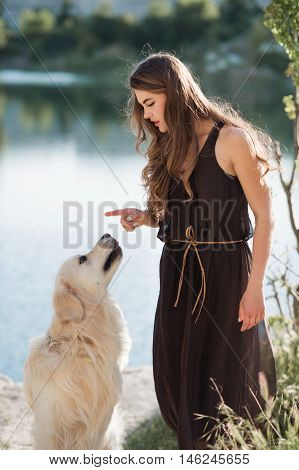 Beauty woman with her dog playing outdoors.