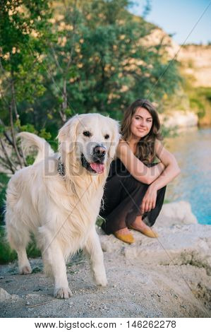 Beauty woman with her dog playing outdoors.
