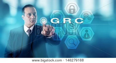 Experienced corporate governance officer is activating GRC onscreen. Business concept and information security metaphor for Governance Risk Management and Compliance procedures and processes.