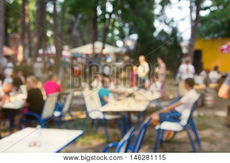 Abstract blur people picnic in public park with family or friends, urban leisure lifestyle. Streed food fest.