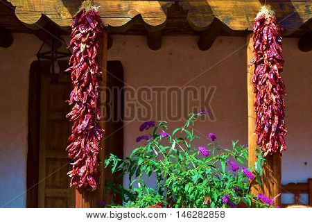Hanging red chili peppers at a southwestern adobe style building which is a New Mexico custom taken in Santa Fe, NM