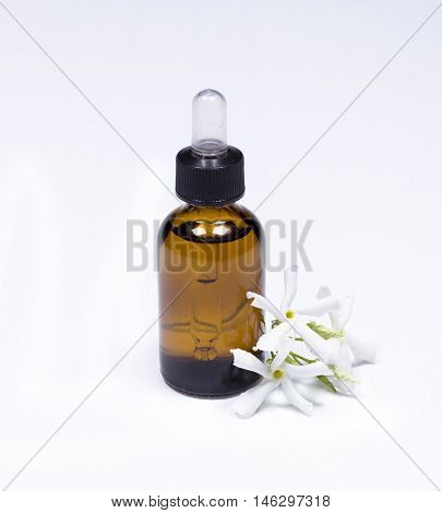 Fresh jasmine flowers and a small glass bottle of essential oil on white background - aroma and skincare concept