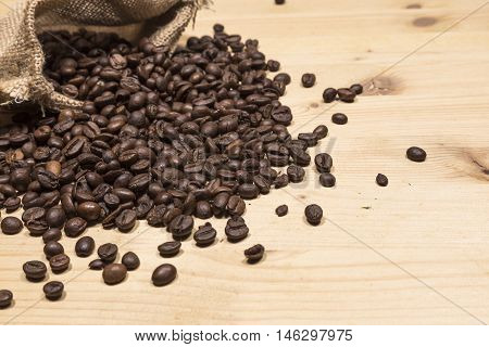 Coffee beans in an old bag on a wooden table