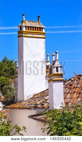 Towers Chimnies Orange Roofs Medieval Town Obidos Portugal. Castle and walls built in 11th century after town taken from the Moors.