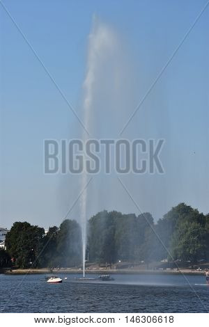 HAMBURG, GERMANY - AUG 26: Fountain at Alster Lake in Hamburg, Germany, as seen on Aug 26, 2016. In the city center, the Alster river forms two lakes, both prominent features in Hamburg's cityscape.