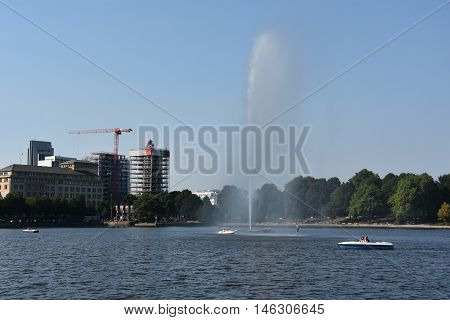 HAMBURG, GERMANY - AUG 26: Fountain at Alster Lake in Hamburg, Germany, as seen on Aug 26, 2016. In the city center, the Alster river forms two lakes, both prominent features in Hamburg's cityscape.