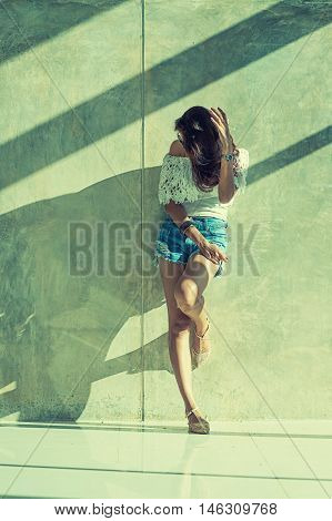 Fashion Portrait Of Young Model Posing By The Wall