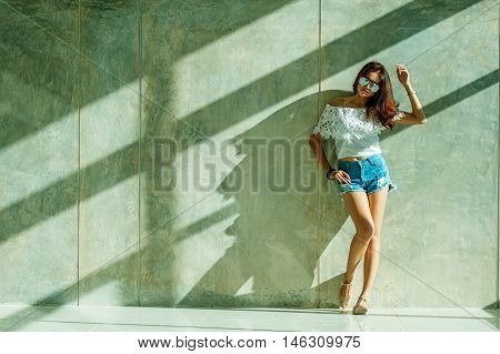Fashion Portrait Of Young Model Posing By The Wall