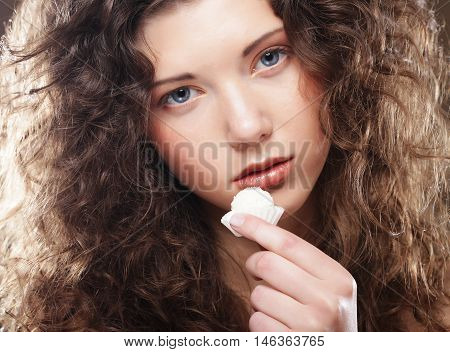 beauty portrait of a cute  girl in act to eat a candy with cocoanut