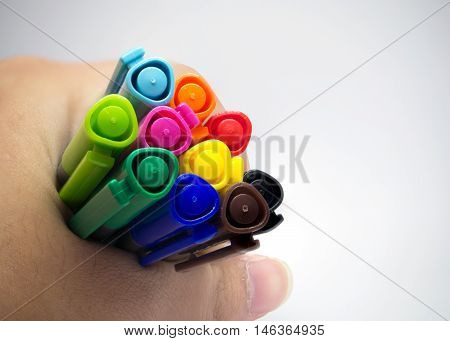 Colorful of pens on hand grey background