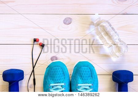 Flat Lay Shot Of Sport Equipment, Shoes, Water, Earphone On Wooden Background.