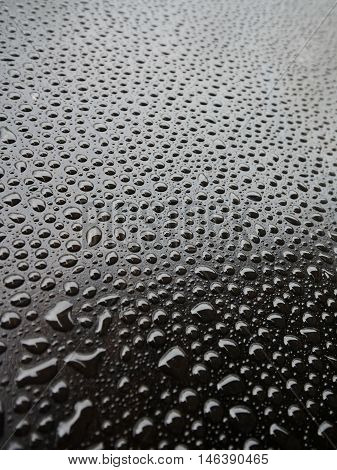 Water drops with tension on the iily surface of a big barbecue grill. Taken in Rothrist, Switzerland