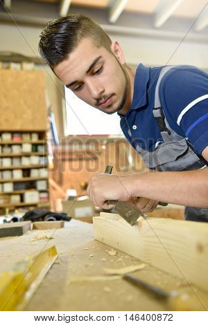 Young man in woodwork crafstmanship school, training course