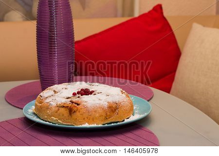 Purple vase and apple pie on the matted glass table