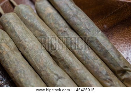 stock of hand made marijuana joints on wooden platter ashtray