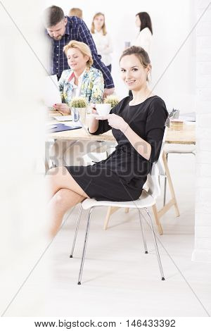 Young manager drinking coffee during a lunchbreak in a bright office