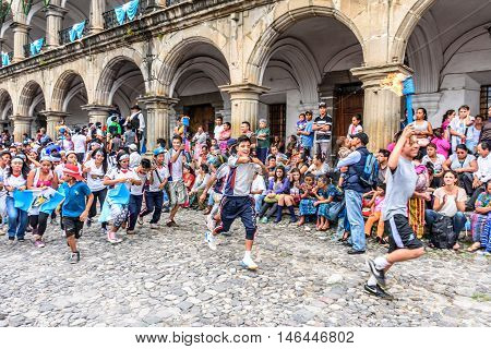 Antigua Guatemala - September 14 2015: Locals run by city hall with lit torches during Guatemalan Independence Day celebrations