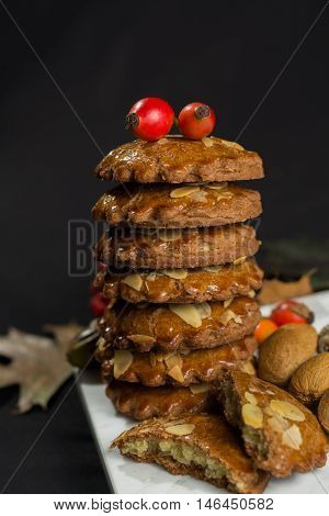 Typical Dutch filled spicy cookies with almonds on autumn colored and dark background