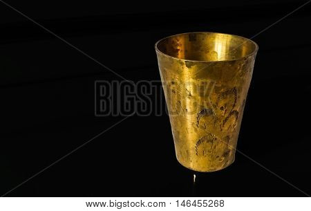 Antique copper cup on a black background