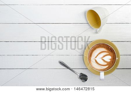 cup of coffeelatte art on white wooden background.