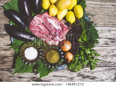 Raw meat and vegetables on woodden background