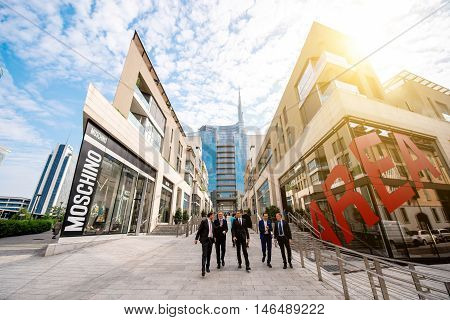 Milan, Italy - June 07, 2016: Businessmen walk on Vincenzo Capelli street with shopping boutiques and offices in Porta Nuova business district in Milan in the morning