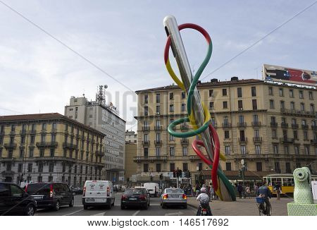 MILAN, ITALY - APRIL 16 2015: The public artwork Needle Thread and Knot in italian Ago Filo e Nodo in Piazza Cadorna in Milan with people and city traffic