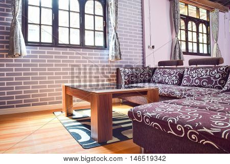 Modern Windowless Living Room Interior With A Feature Grey Brick Wall And Comfortable Corner Unit Lo