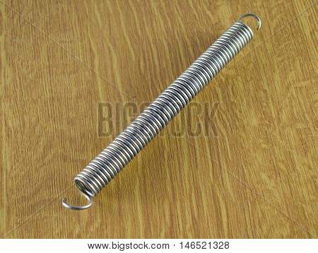 Compressed tension spring on a table on a laminated worktop.