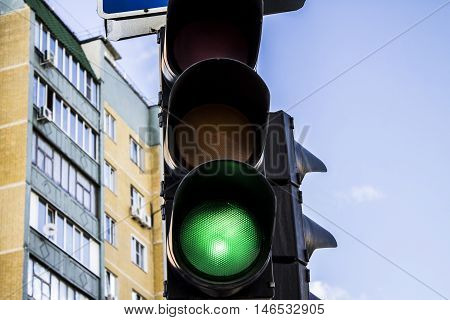 the green traffic signal against the background of the house