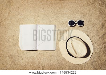 Top view of sandy beach with summer accessories and copy space around products. Blank mock up for advertising or packaging.