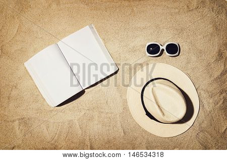 Top view of sandy beach with summer accessories and copy space around products. Blank mock up for advertising or packaging.