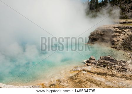 Light blue pool Excelsior geyser with steam rising from hot spring in Midway basin in Yellowstone National Park by Grand Prismatic