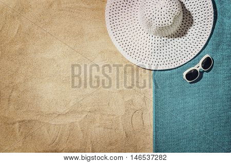Top view of sandy beach with summer accessories and copy space around products. Blank mock up for advertising or packaging.