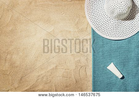 Top view of sandy beach with summer accessories and copy space around products. Blank mock up for advertising or packaging.