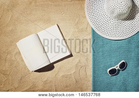 Top view of sandy beach with summer accessories and copy space around products. Blank mock up for advertising or packaging.
