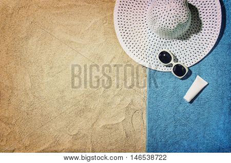 Top view of sandy beach with summer accessories and copy space around products. Blank mock up for advertising or packaging.