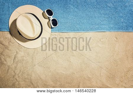 Top view of sandy beach with summer accessories and copy space around products. Blank mock up for advertising or packaging.