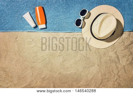 Top view of sandy beach with summer accessories and copy space around products. Blank mock up for advertising or packaging.