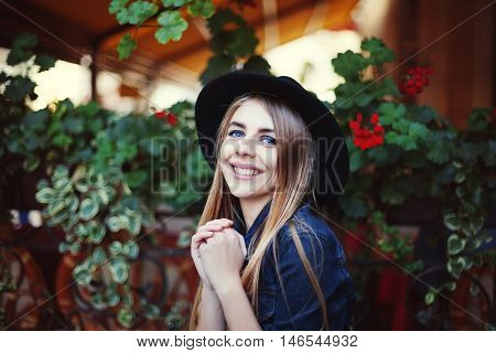 Portrait of beautiful surprised girl. Colorful background. Model wearing stylish black hat. Lady looking at camera