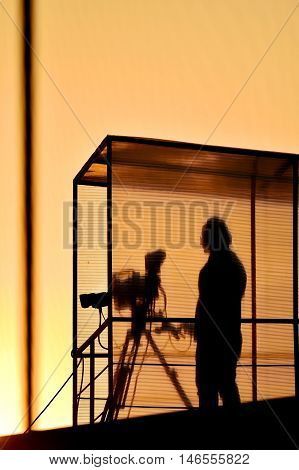 Cameraman's silhouette broadcasting live from a stadium