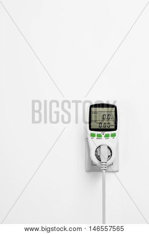 Electric power consumption meter isolated on white wall. Power saving concept or background.