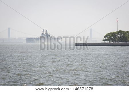 JERSEY CITY NJ - MAY 31 2016: USS Bataan (LHD 5) passes Liberty Island on the Upper New York Bay upon departing Manhattan marking the end of Fleet Week 2016, seen from Liberty State Park.