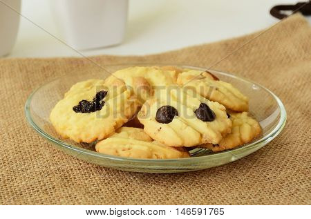 Chocolate chip cookies on brown colored cloth on white table