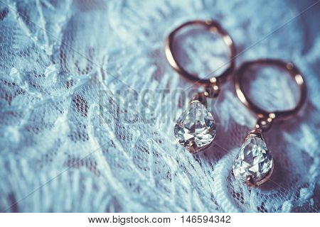 Fine jewelry: earrings on the white wedding dress